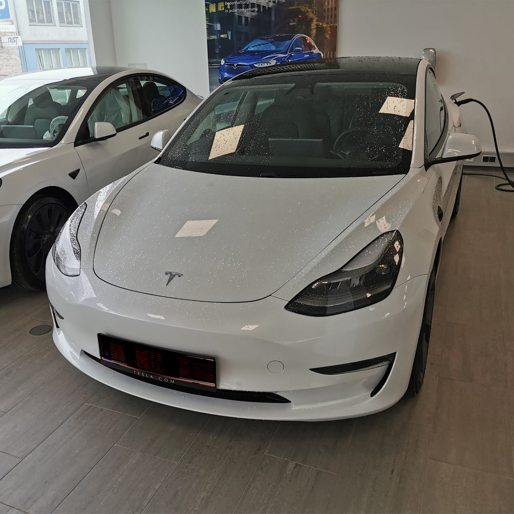 Witte Tesla Model 3 bij de overdracht in de showroom
