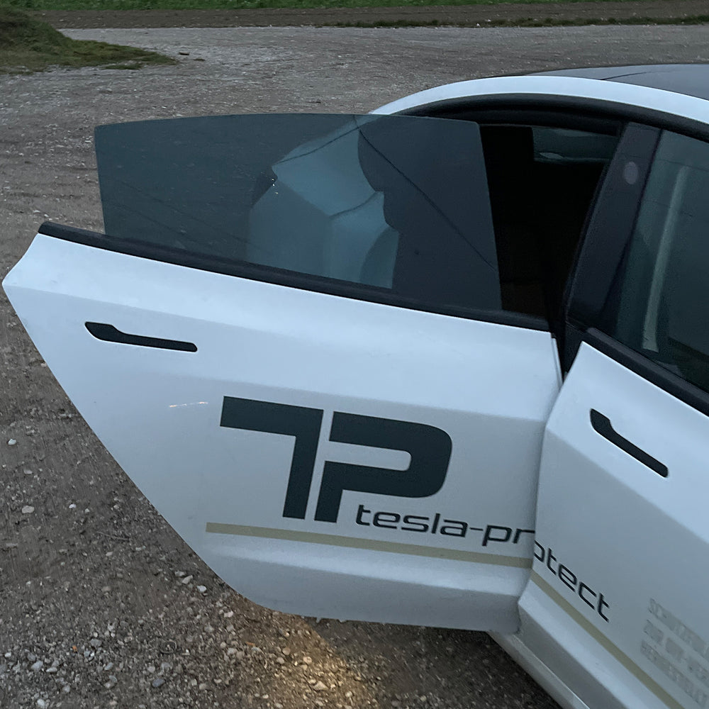 Getinte achterste zijruit van een witte Tesla Model 3