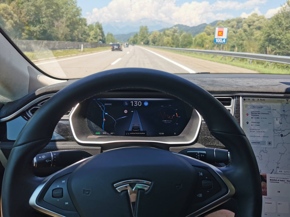 Blik over het stuur van een Tesla Model X op de snelweg