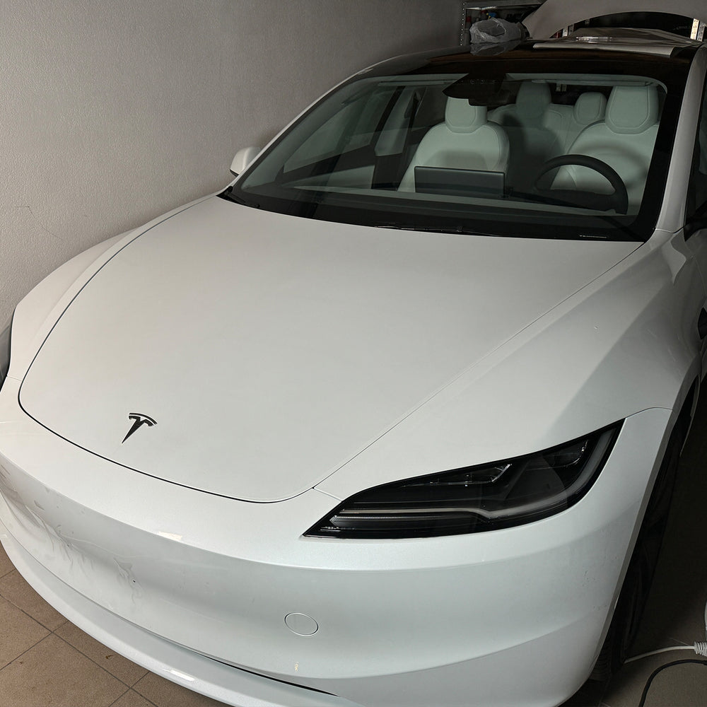 Witte Tesla Model 3 „Highland” van voren in de werkplaats